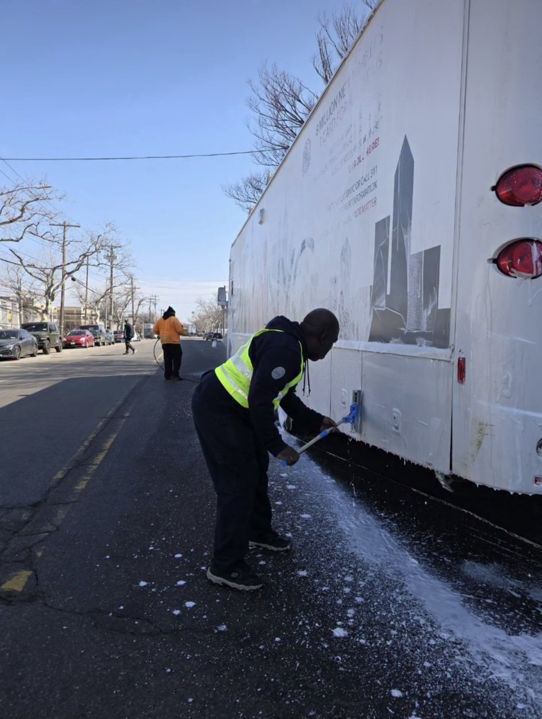 Worker washing a truck exterior